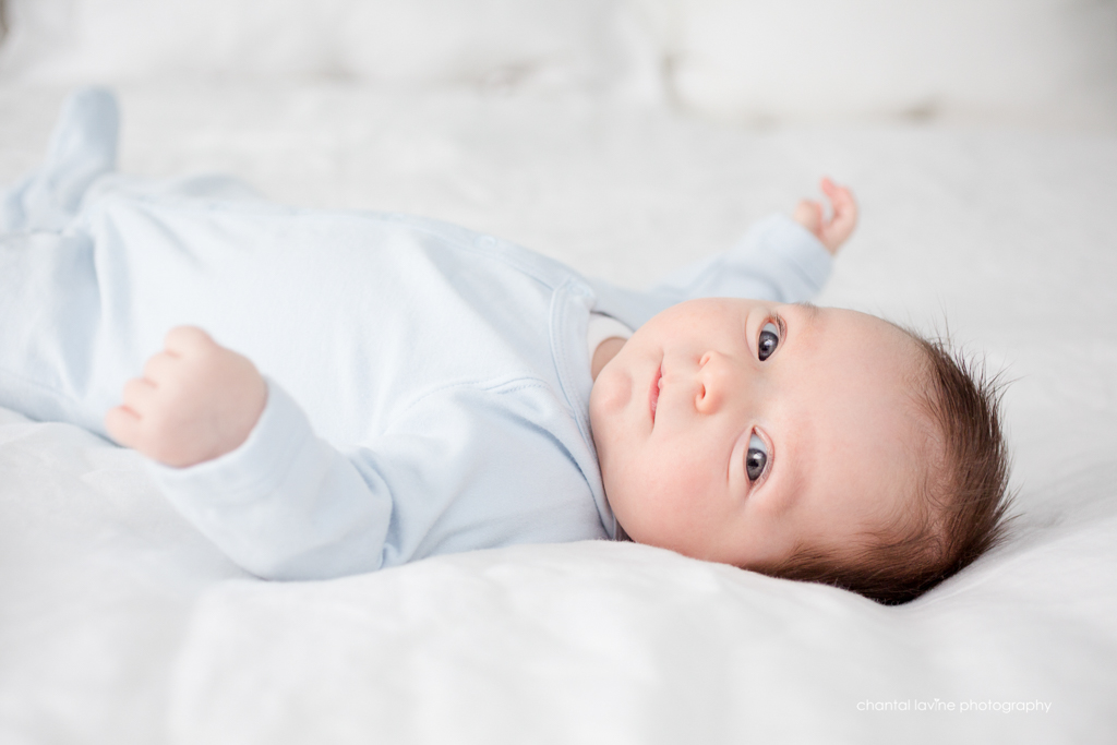 newborn-boy-stares-at-camera-from-bed